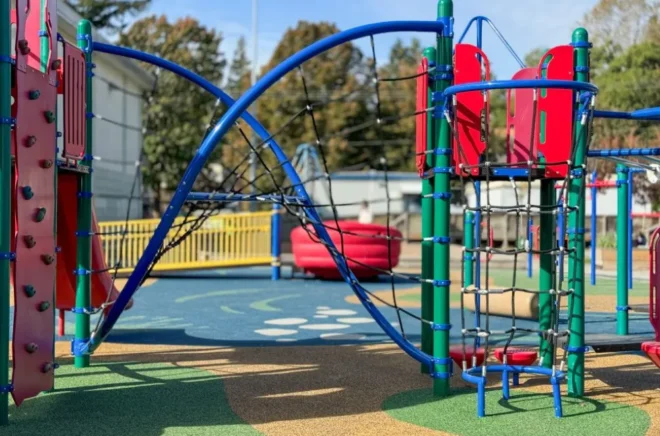 Juegos de trepa con redes de cuerdas y estructuras de colores en un patio de educación básica