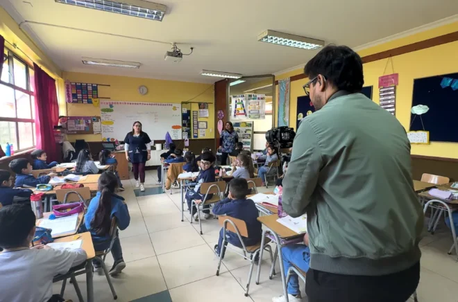 Camarógrafo registrando una clase con docentes y estudiantes para un vídeo institucional